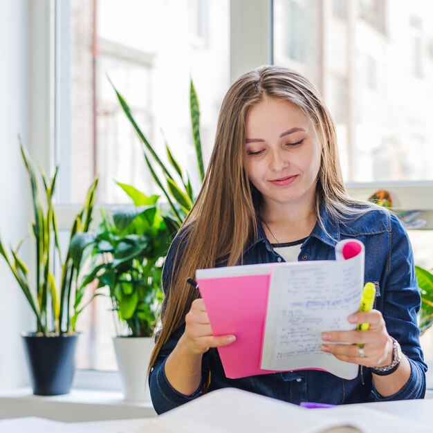 Charming female student reading notes