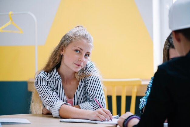 Charming girl in classroom with students