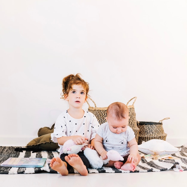 Charming girl and cute baby in nursery