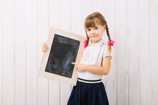 Charming girl pointing at blackboard