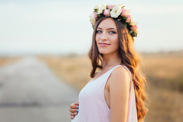 The charming girl stands in the field