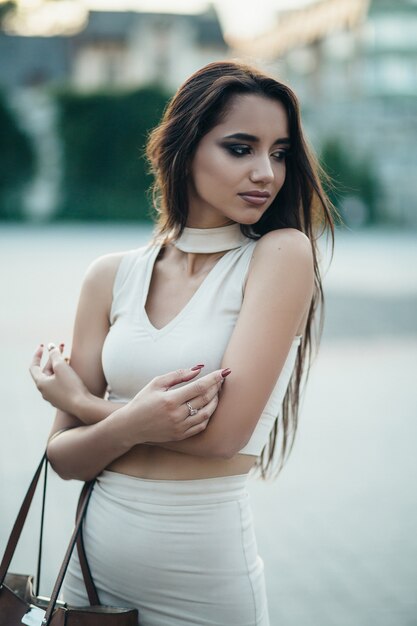 The charming girl stands on the street