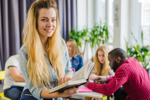 Charming girl with book posing in room