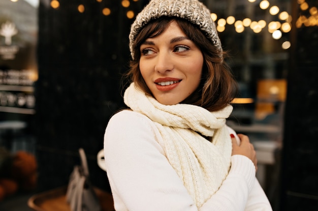 Charming girl with long dark hair in knitted hat