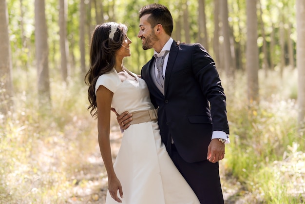 Charming groom hugging his bride outdoors