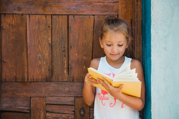 Charming kid enjoying book