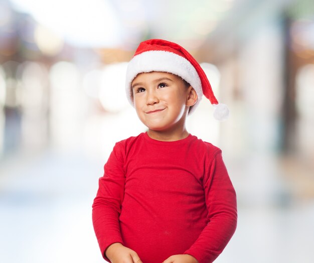 Charming kid with santa hat looking up