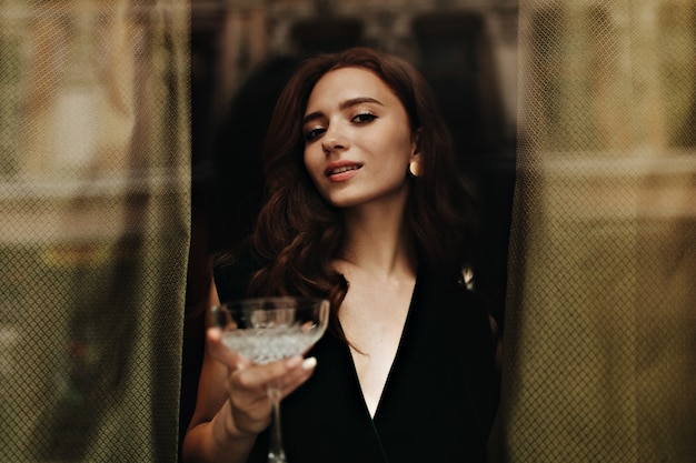 Free photo charming lady in velvet outfit holds martini glass