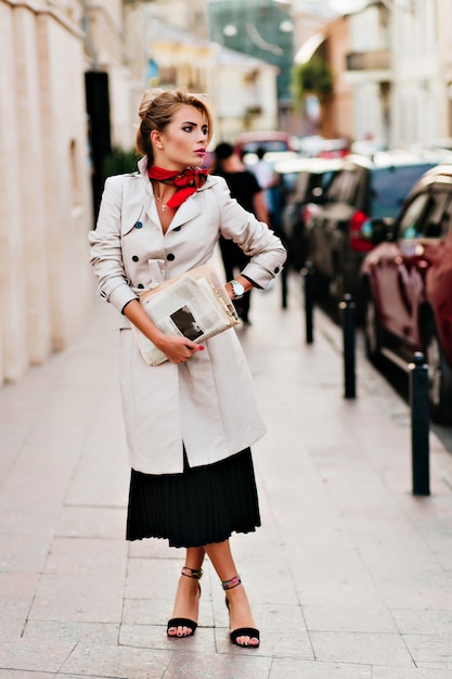 Foto gratuita affascinante signora con acconciatura elegante in attesa di qualcuno per strada e guardandosi intorno