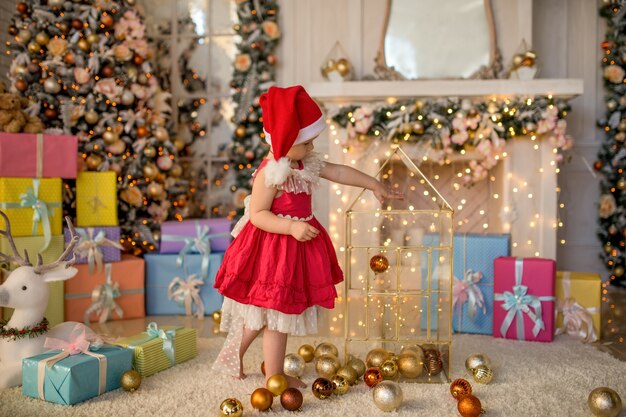 魅力的な少女は、クリスマスツリーのおもちゃで遊ぶ