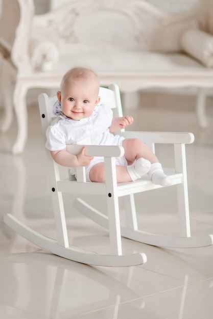 Free photo charming newborn boy sits on the chair in the studio