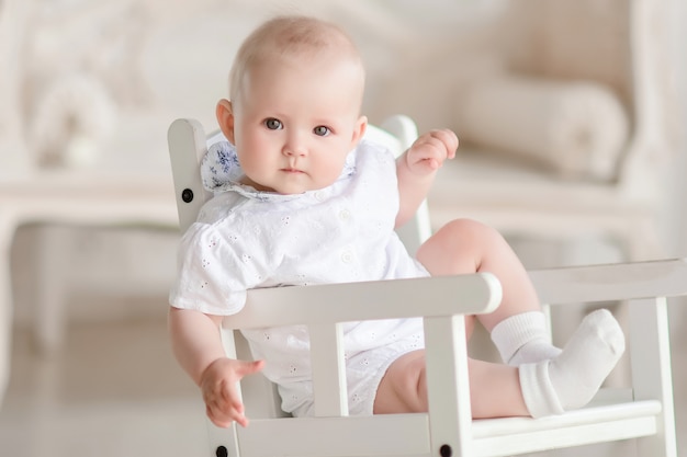 Free photo charming newborn boy sits on the chair in the studio