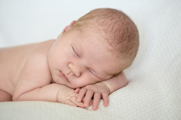 Очаровательная новорожденная девочка спит на животе