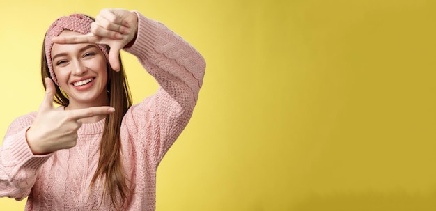 Free photo charming outgoing happy girl smiling cheerful making frame of fingers looking through it excited and