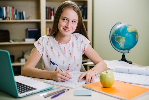 Charming schoolgirl posing at desktop