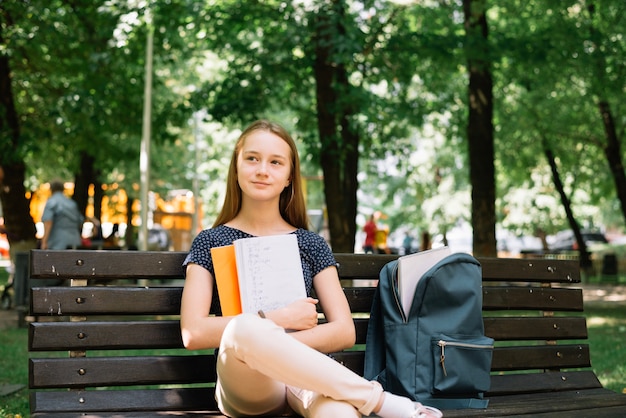 Free photo charming student daydreaming on bench