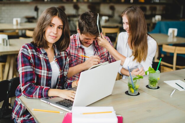 魅力的な学生はテーブルでポーズを取る