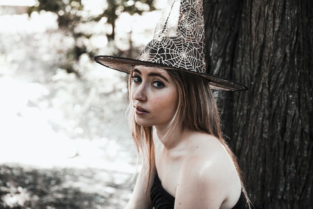 Charming witch in sunny woods