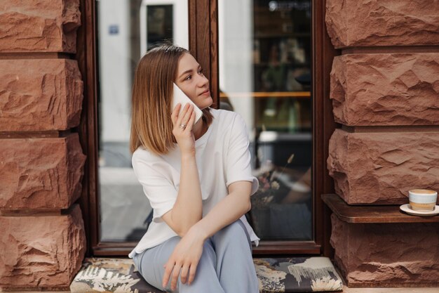 Charming woman in cafe talking at cellphone