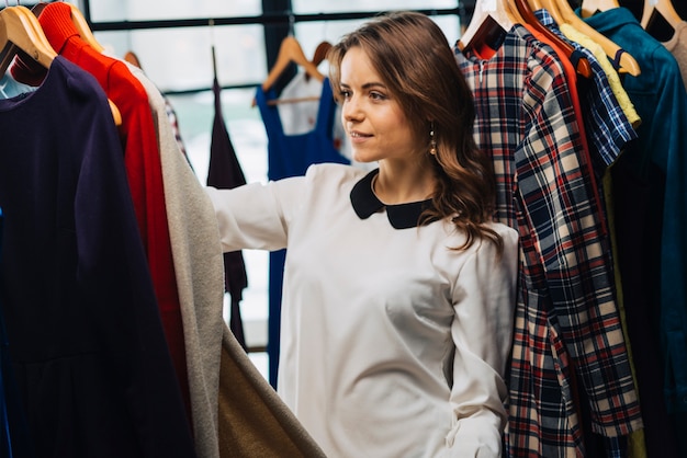 Charming woman choosing clothes in store