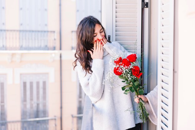 Charming woman excited with bouquet from girlfriend