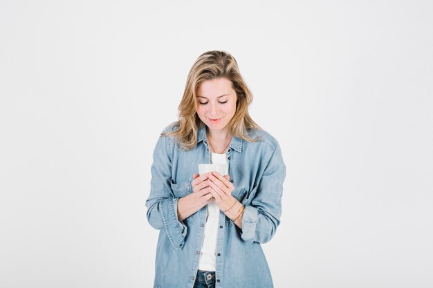 Charming woman holding cup of hot beverage