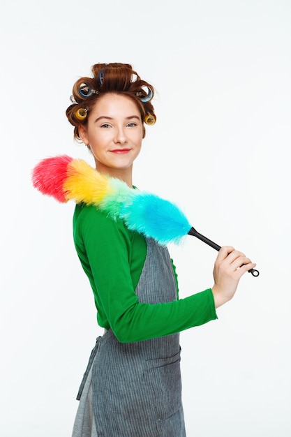 Free photo charming woman posing while working with duster in hands