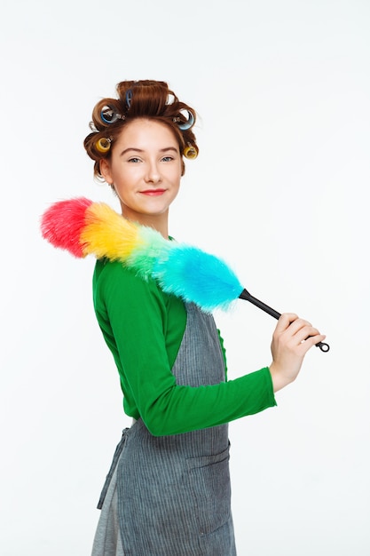 Charming woman posing while working with duster in hands