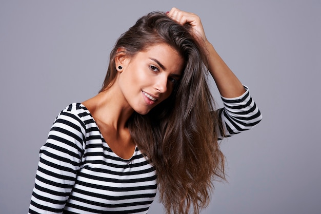 Charming woman posing with her hand in hair