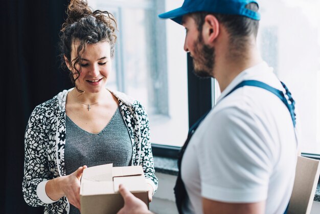 Charming woman receiving parcel with courier