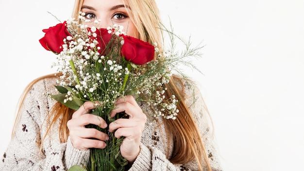 Foto gratuita rose sententi l'odore della donna affascinante