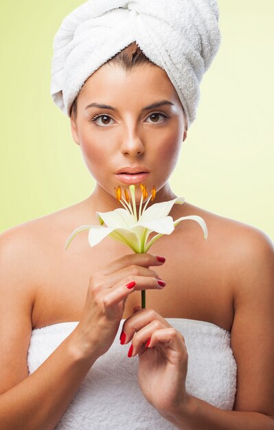 Charming woman in towel with lily