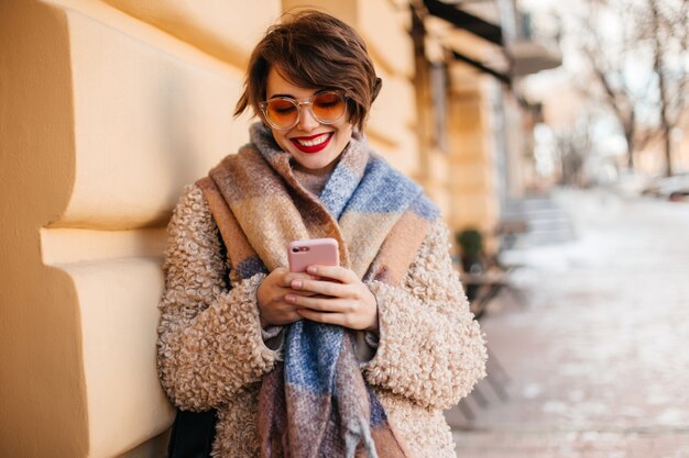 Charming woman using smartphone on street