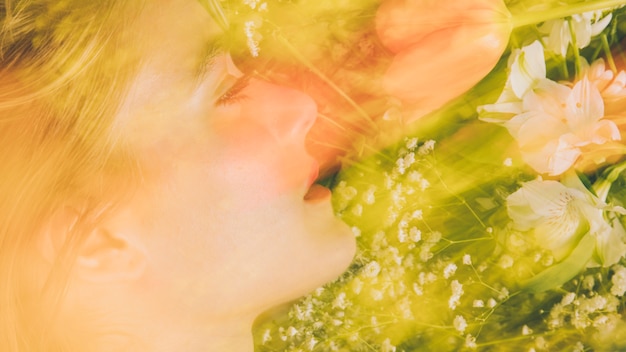 Charming woman with bouquet of flowers in greenness