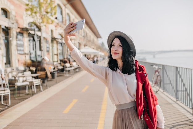 晴れた日に自分の写真を撮るかわいい笑顔の魅力的な女性