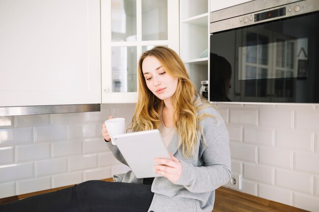 Charming woman with tablet and mug 