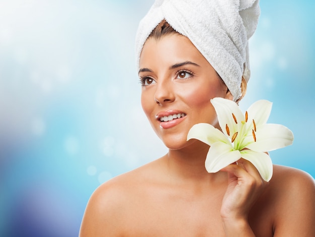 Free photo charming woman with white lily wearing towel on head