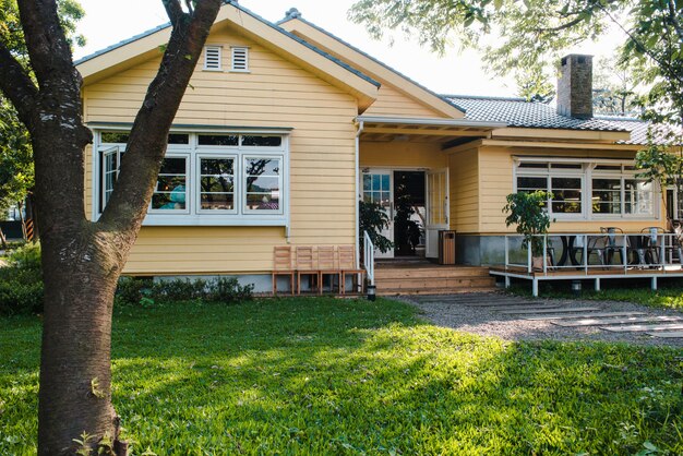 Charming yellow house with wooden windows and green grassy garden