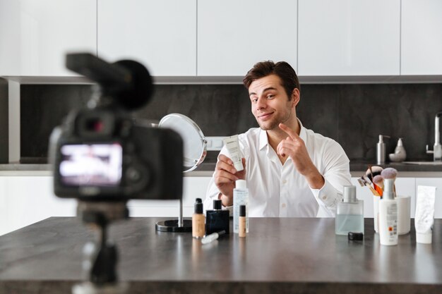 Charming young man filming his video blog episode