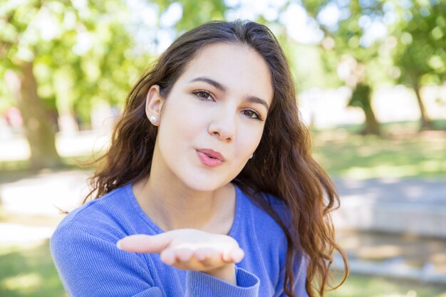 空気キスを吹いて魅力的な若い女性