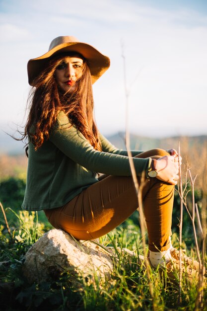 Charming young woman posing on stone