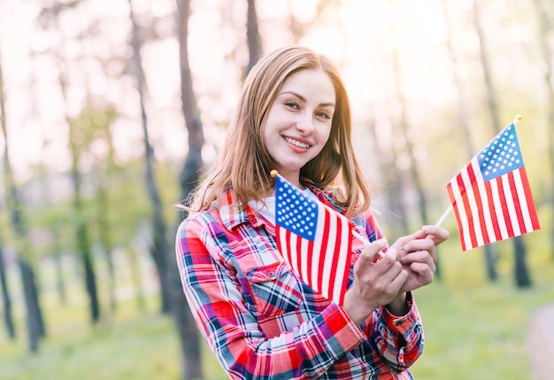 Очаровательная молодая женщина с американскими флагами