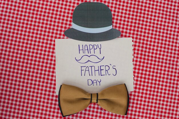 Checkered surface with bow tie and hat for father's day