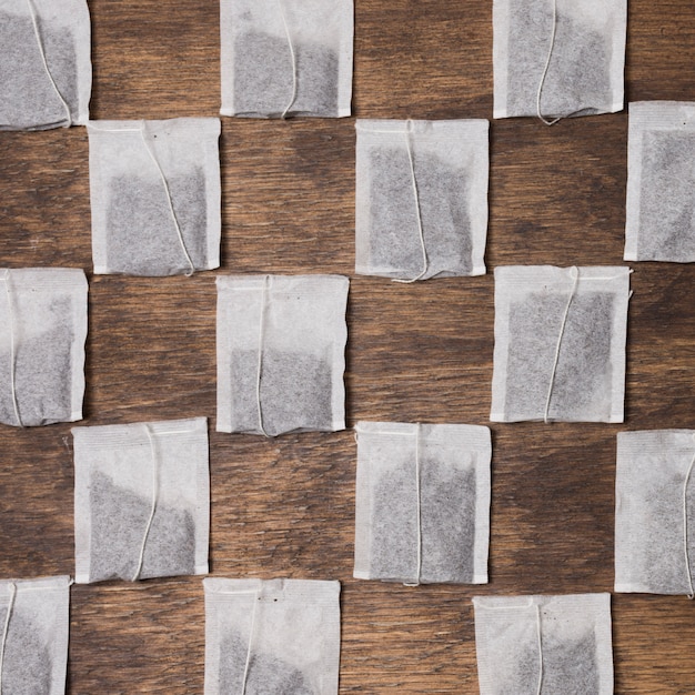 Free photo checkered tea bag on wooden textured background