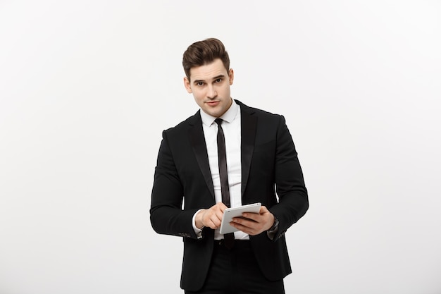 Checking statistics. Successful and confident businessman stands and checks online news on the tablet inside business center. Young business in formal suit.
