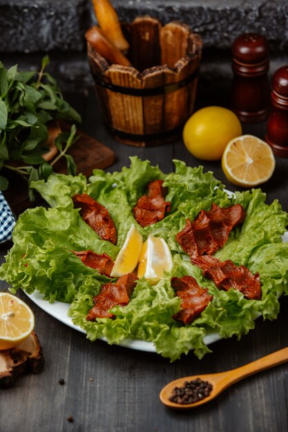 chee kofta turkish raw meatball plate on lettuce leaves with lemon