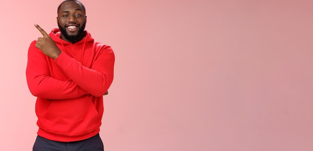 Free photo cheeky outgoing smiling attractive africanamerican male model in red hoodie grinning energized