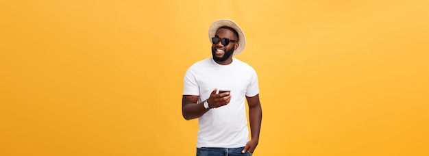 Cheerful african american man in white shirt using mobile phone application happy dark skinned hipst