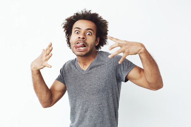 Cheerful african man making funny face fooling.