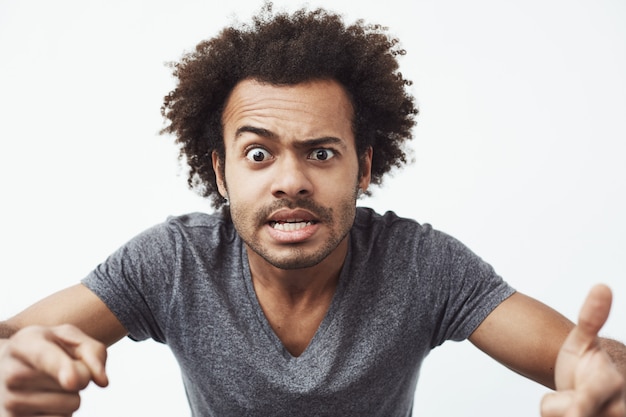 Cheerful african man making funny face fooling.